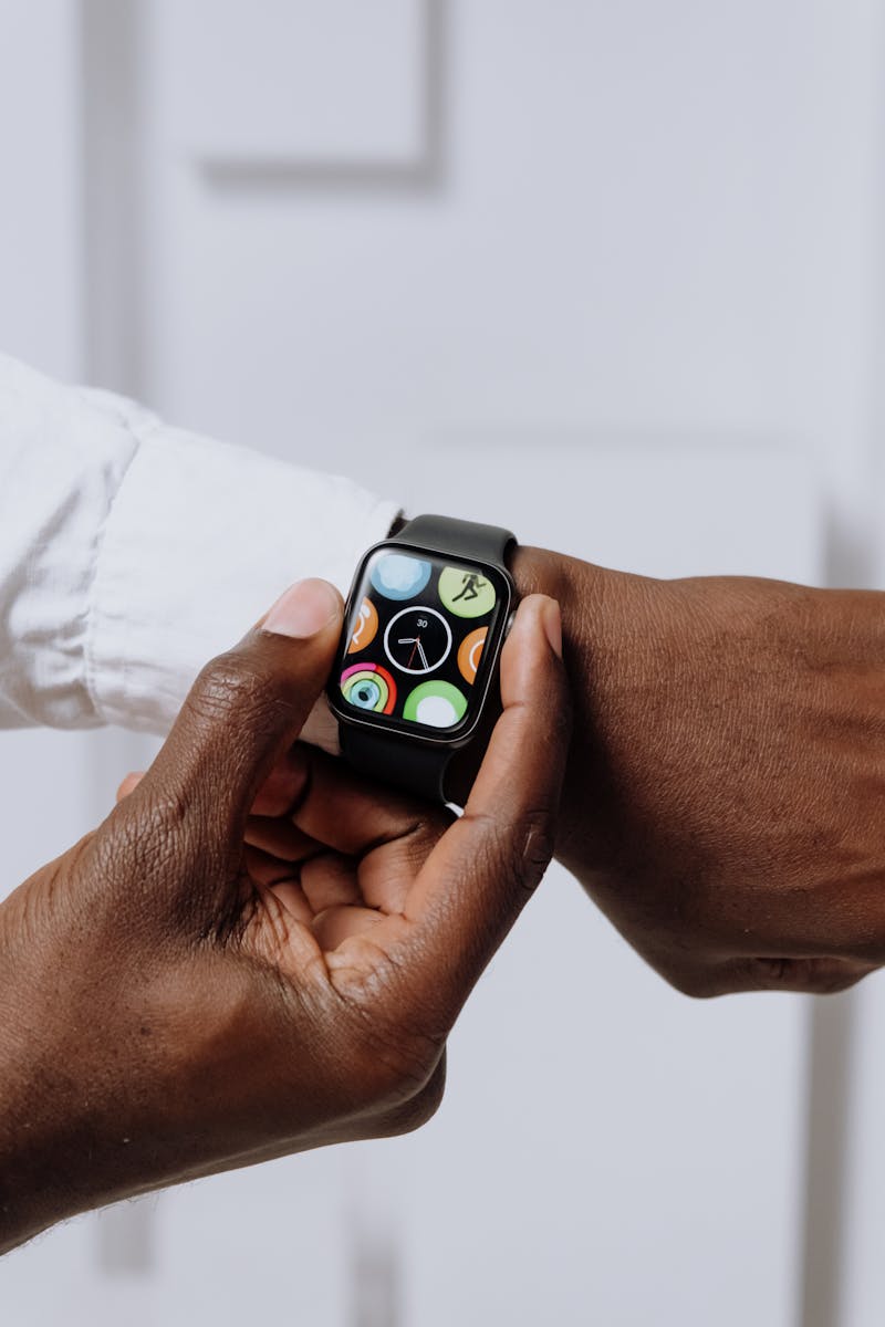 Close-up of two hands interacting with a smartwatch, emphasizing modern technology.